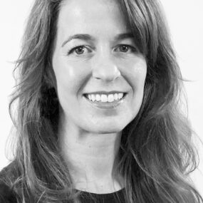 Black and white headshot of white woman with long, dark hair