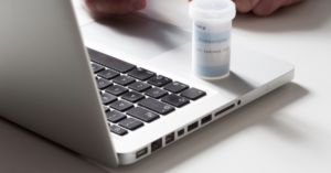 Laptop with a prescription bottle sitting on it
