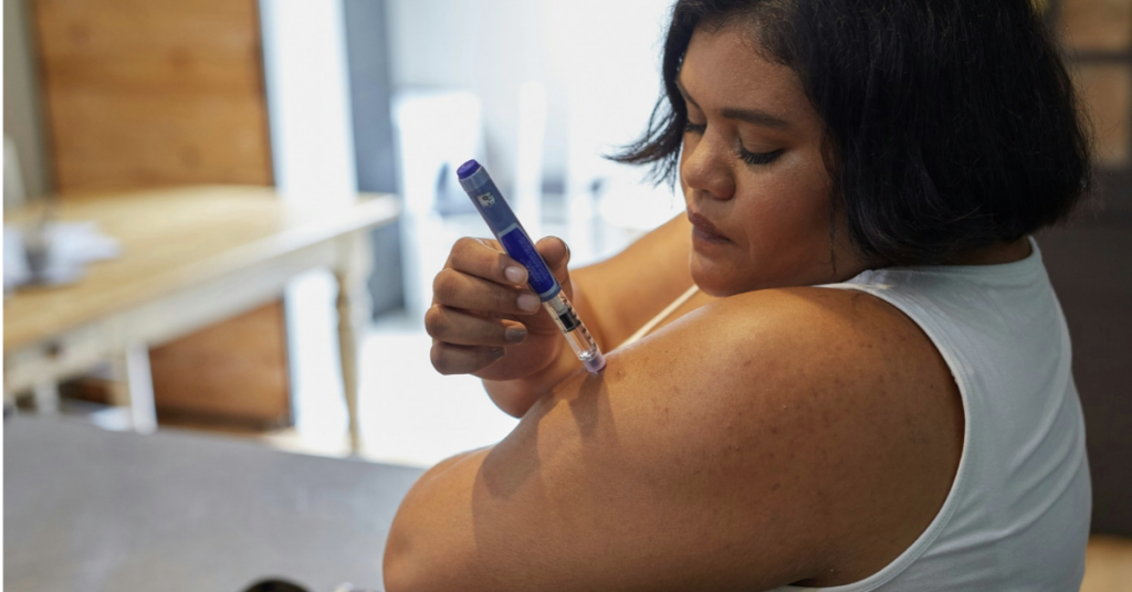 woman injecting herself with an insulin pen