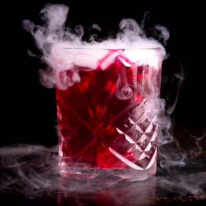 Red beverage with cloud of dry ice 